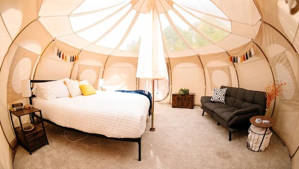 A cozy tent with a bed, a sofa, a small table, and a lamp. - Yellowstone Luxury Bell Tent Sleeps 3 (Island Park)