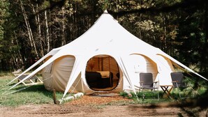 A dome-shaped tent with an open entrance, two chairs, and a solar panel outside. - Yellowstone Luxury Bell Tent Sleeps 3 (Island Park)