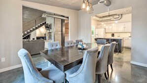 Una cocina moderna con armarios blancos, una isla central y electrodomésticos de acero inoxidable.