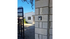 Ein begrenzter Eingang mit einem Metallgitter und einer Backsteinmauer.