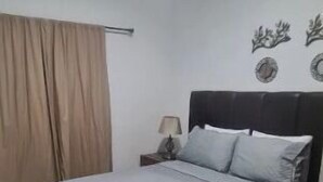Ein Schlafzimmer mit Bett, Vorhängen, Nachttisch und Wanddekorationen.