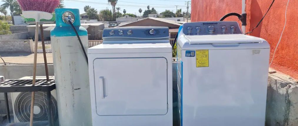 Two stacked washing machines in an outdoor setting.
