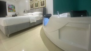 Een moderne hotelkamer met een bed, een ruime badkuip en een wand met ingelijste foto's.