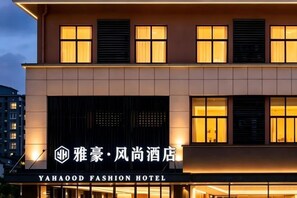 Een hotelgebouw met verlichte reclameborden en een moderne gevel.