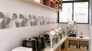 Een moderne keuken met een koffiehoek, inclusief een koffieapparaat, maalderijen en opbergcontainers.