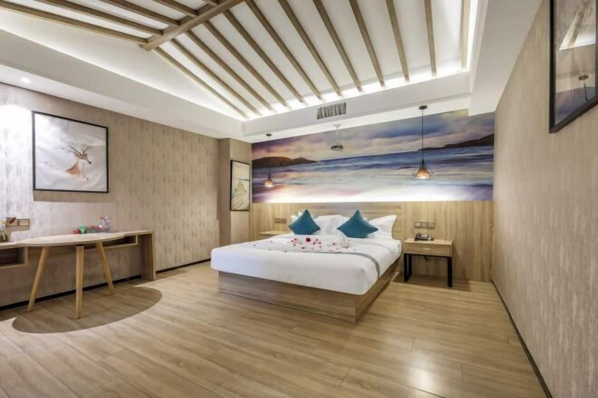 Une chambre moderne avec un plafond en bois, un grand lit avec des oreillers bleus, un bureau et une fresque murale.