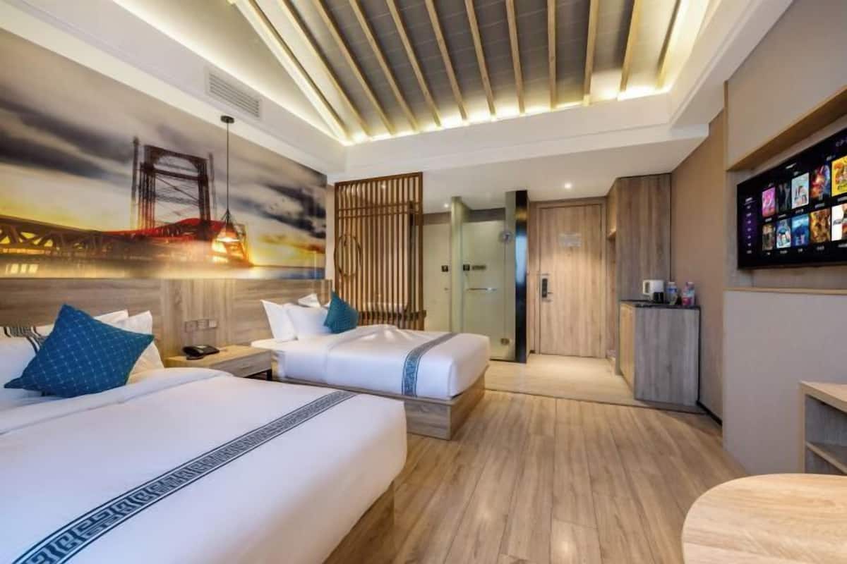 Une chambre d’hôtel avec deux lits, une télévision, un bureau et une salle de bain.