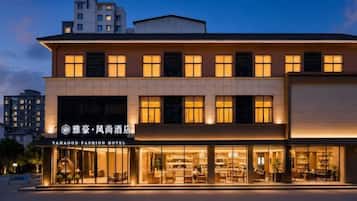 A modern hotel building with a ground-floor retail space and a visible entrance.