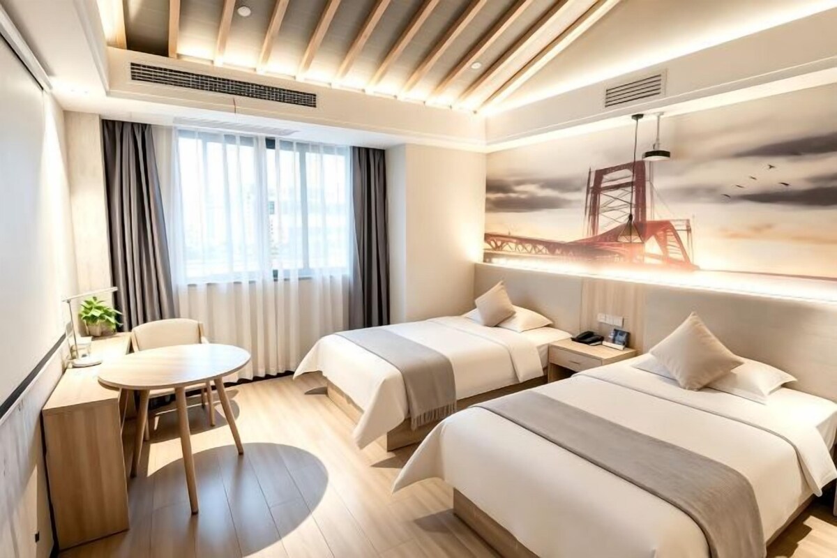 Een hotelkamer met twee bedden, een bureau en een stoel.