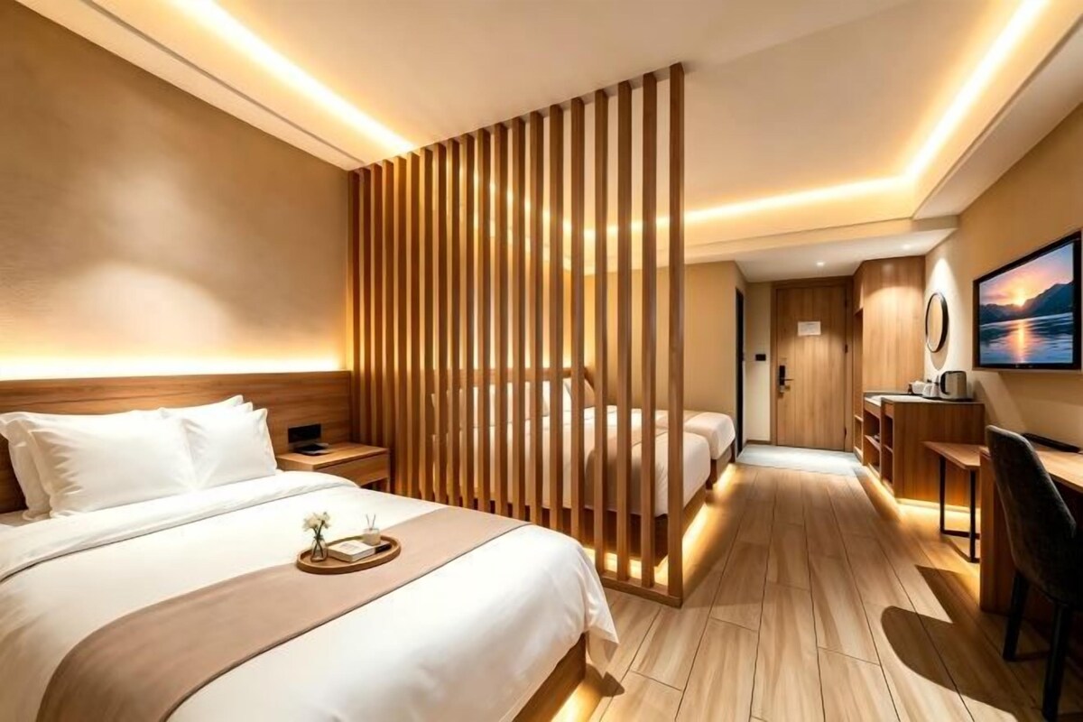 A hotel room with a large bed, a desk, and a view of the outdoors.