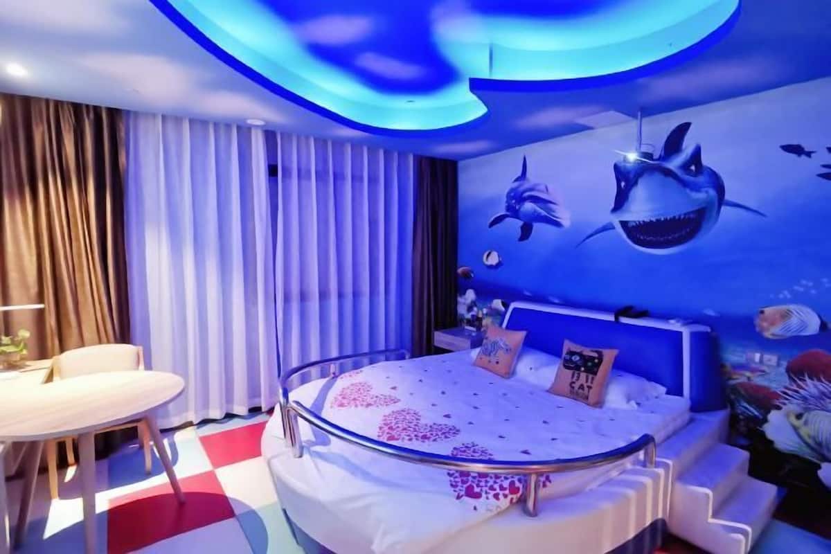 Une chambre à coucher avec un lit, un bureau et des rideaux.