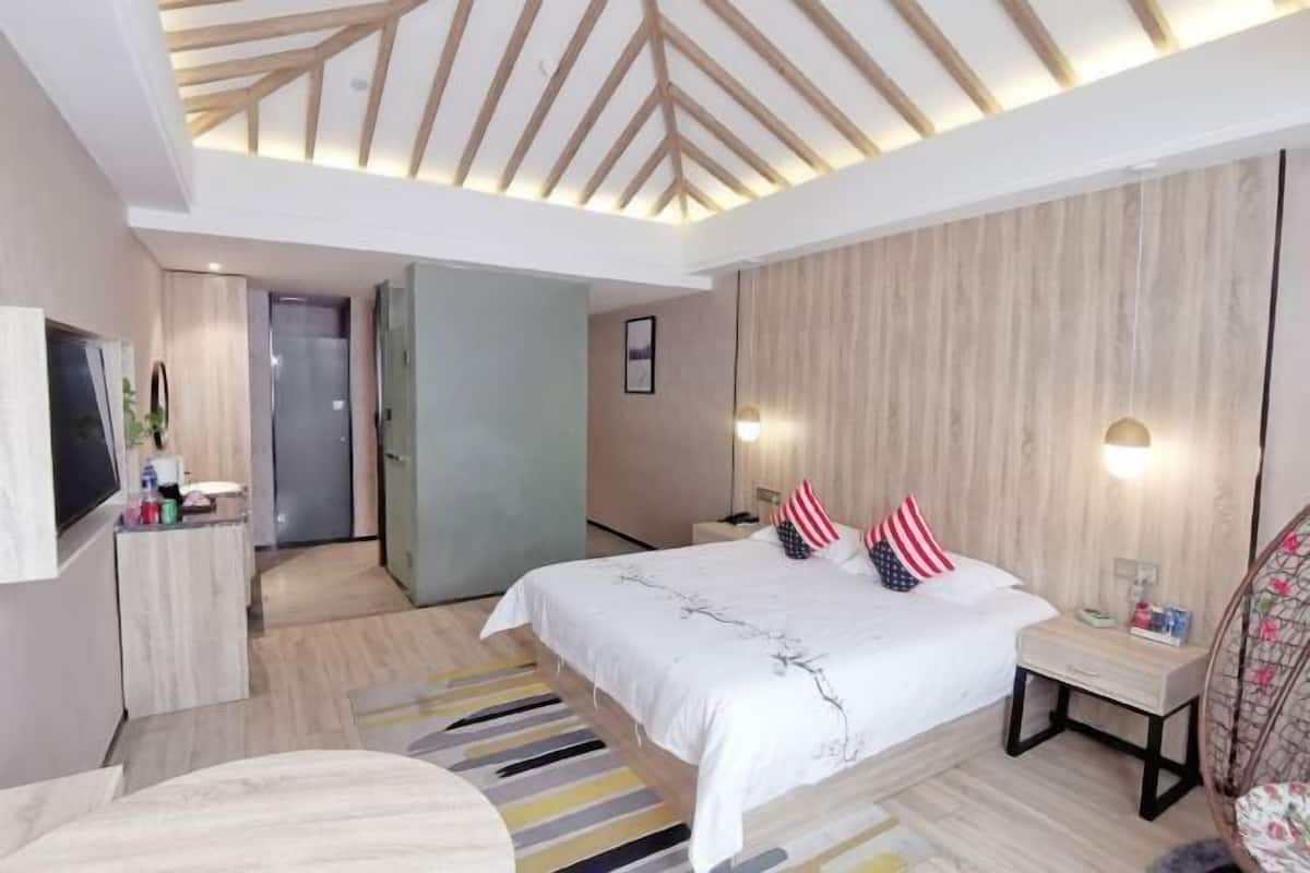Une chambre d’hôtel moderne dotée d’un grand lit, d’un bureau, d’une télévision et d’un dressing.