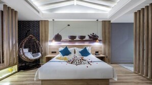 Een moderne slaapkamer met een groot bed, een hangstoel en een wandplank met decoratieve objecten.