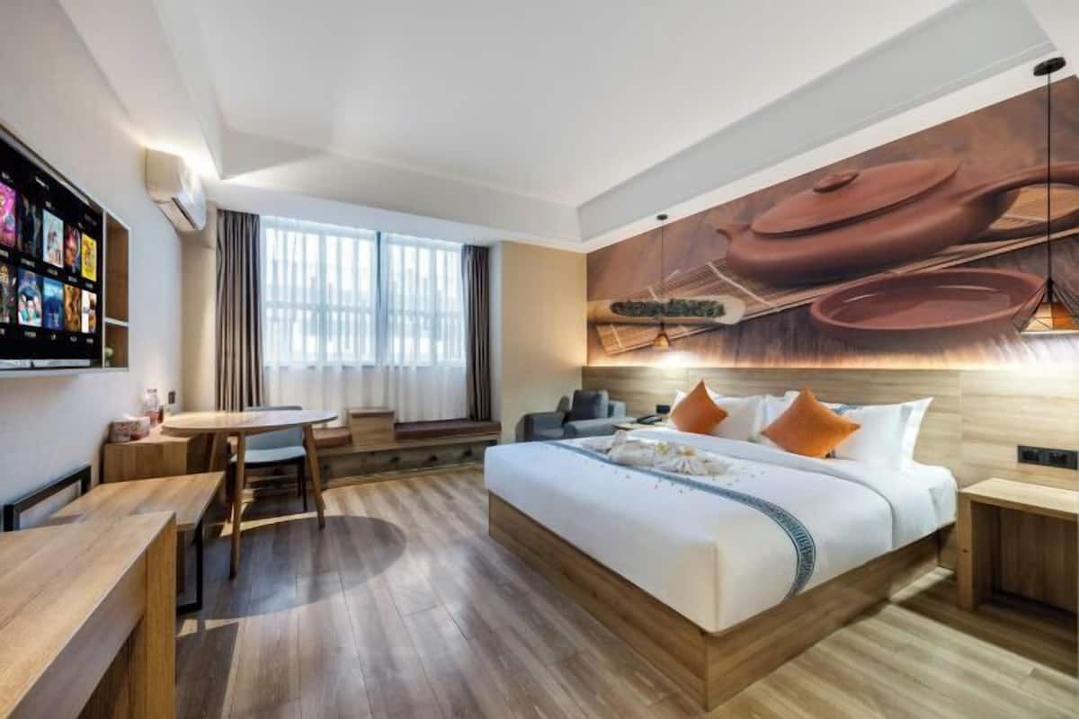 Une chambre d’hôtel moderne équipée d’un grand lit, d’un bureau et d’un coin repas.