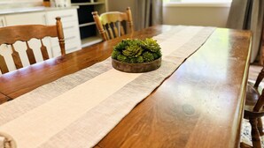 A wooden dining table with a woven placemat, a small potted succulent, and chairs. - Spacious, private and peaceful 1st floor Apartment on Fly Creek  (Fly Creek)