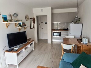 Een moderne keuken met witte kastjes, een ingebouwde oven en een witte koelkast.