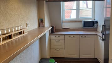 Een mini-koelkast, een magnetron, kookgerei, borden en bestek