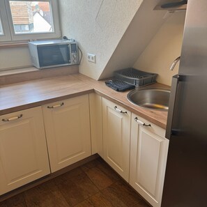 Mini-fridge, microwave, cookware/dishes/utensils, cleaning supplies