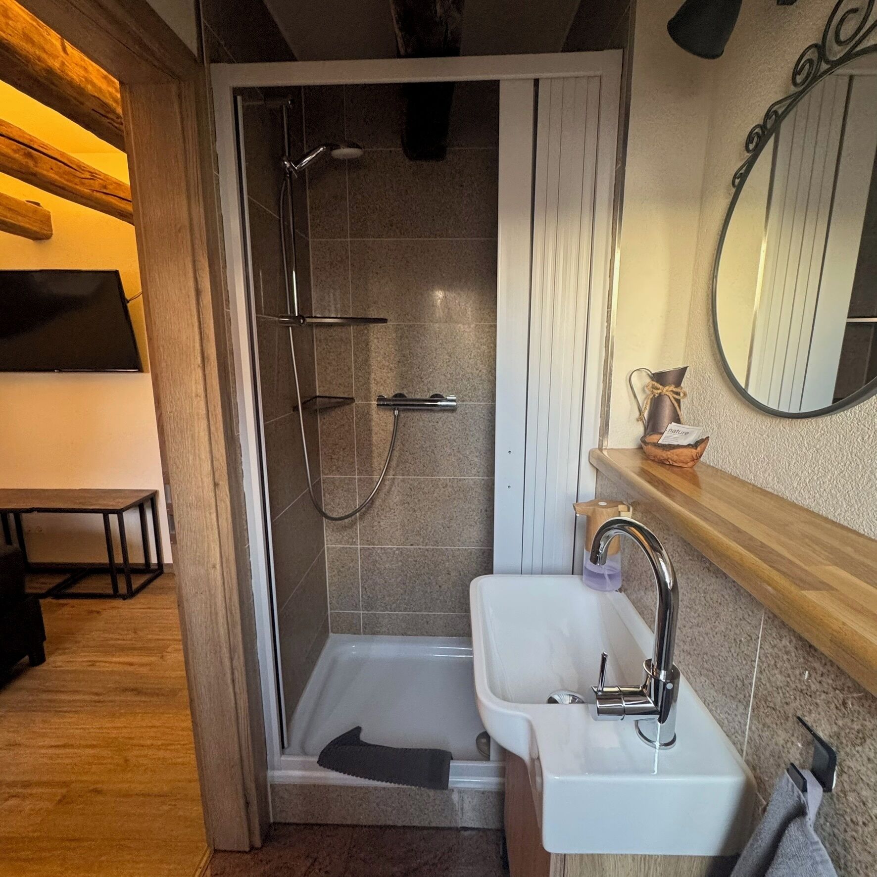 Un baño con ducha, lavabo y espejo.