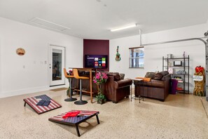 Uma sala de estar com um sofá de couro marrom, uma mesa de centro e uma TV fixada na parede.