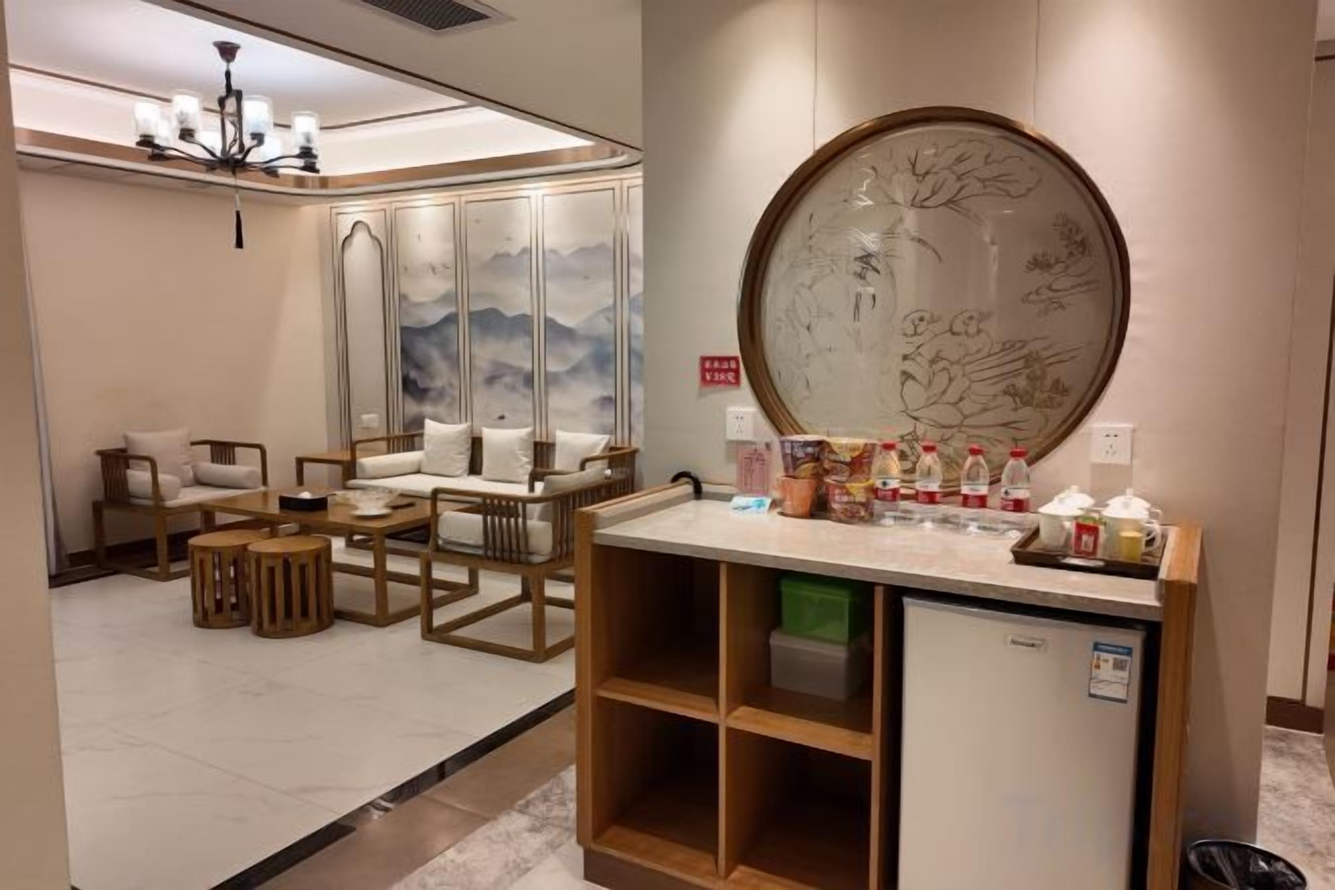 Una hall d'albergo con reception, area salotto e parete decorativa.