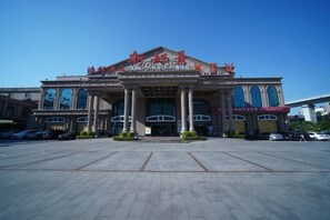 Un edificio grande con una entrada destacada y columnas, con señalización en un idioma extranjero.