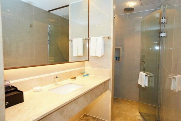 A modern bathroom with a glass shower enclosure, a large mirror, and a marble countertop. - New Haojing Hotel (Guangzhou Xintang Metro Station) (Guangzhou)