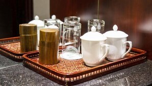 Un plateau contenant divers récipients en verre et des tasses en céramique blanche, probablement destinés à servir des boissons.