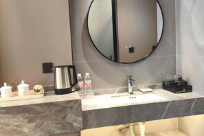 Enjoy a clean and functional bathroom with a large mirror, sink, and convenient amenities.