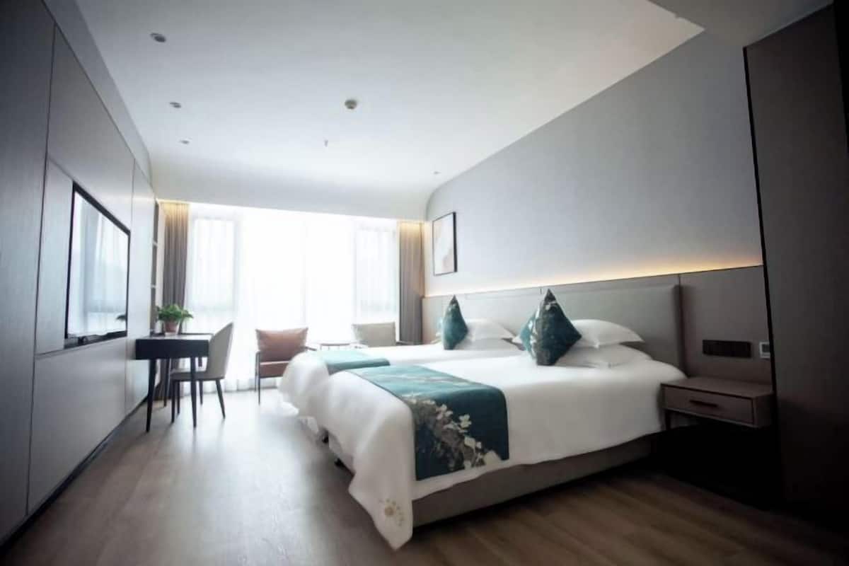Una habitación de hotel moderna con una cama grande, un escritorio y una silla.