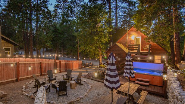 Ein gemütlicher Außenbereich mit Whirlpool, Holzterrasse und Steinmauer.