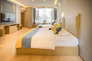 Quarto de hotel com uma cama grande, televisão e janela com cortinas.