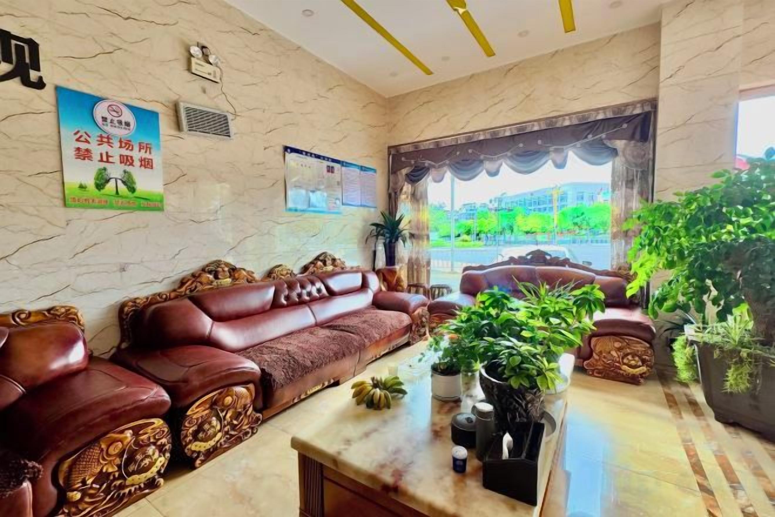 A lobby with a sofa set, a marble coffee table, and potted plants.