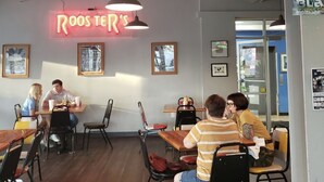 Un restaurant décontracté avec une enseigne au néon sur laquelle on peut lire « Roos Ter's ».