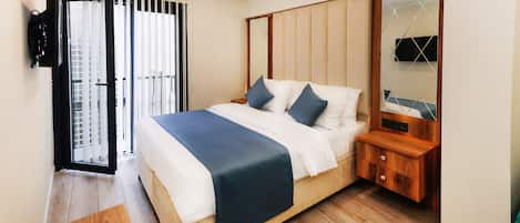 A bedroom with a bed, bedside table, and a mirror.