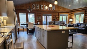 Una cocina amplia con una isla grande, muebles de madera y un comedor con vistas al exterior.