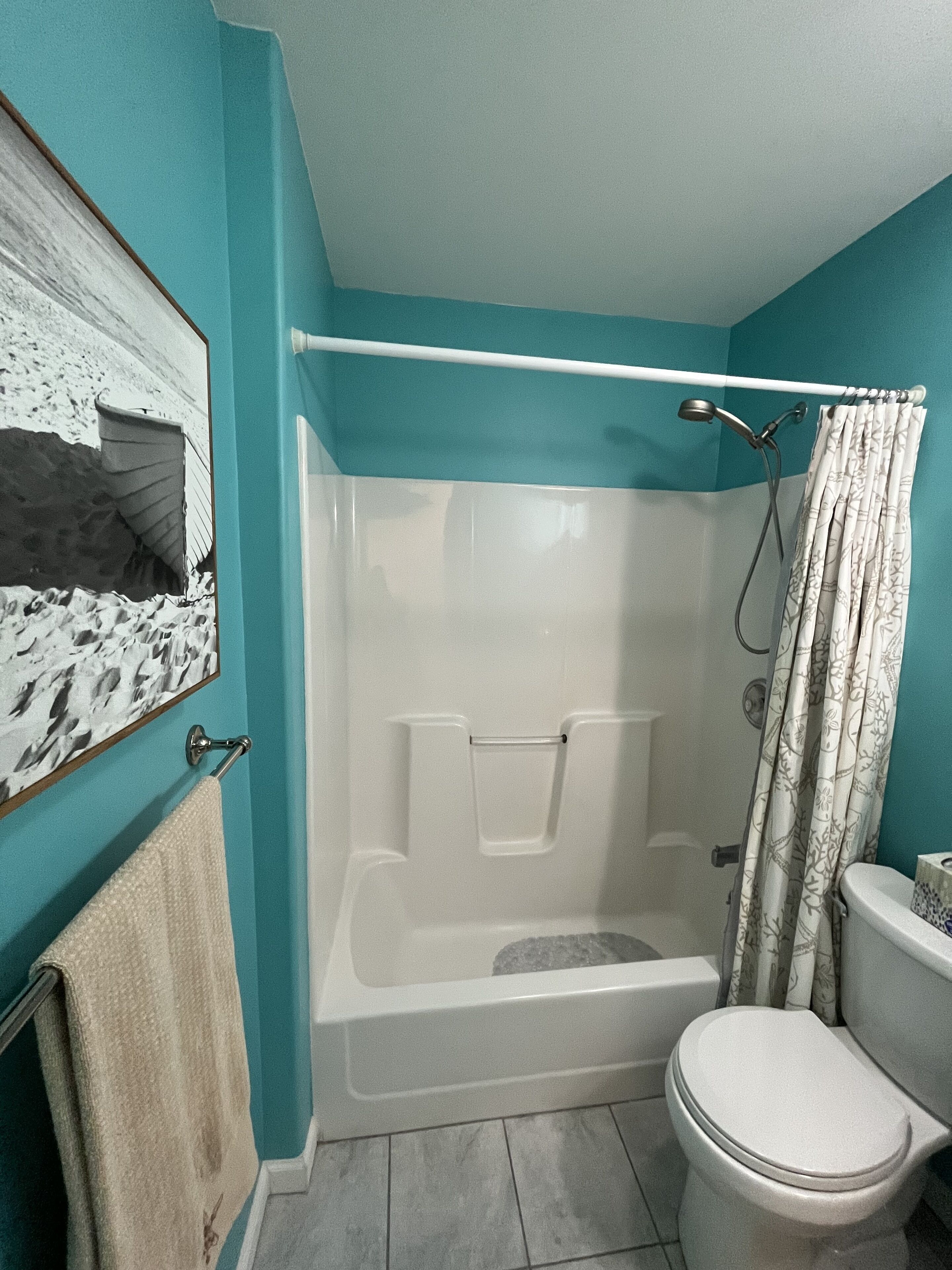 Une salle de bain avec une baignoire, des toilettes et un rideau de douche.