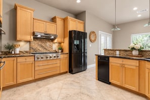 A kitchen with wooden cabinets, a stainless steel stove, a black refrigerator, and a dishwasher. - McKenzie Cove - Private dock & lake views (Hot Springs)