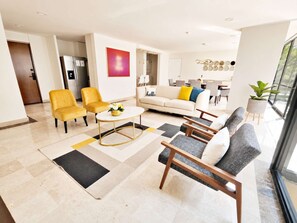 A modern living room with a sofa, armchairs, a coffee table, and a dining area in the background. - Cordelia · 180 m² in the heart of Polanco · 3 baths (Ciudad de México)