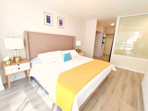 Ein Hotelzimmer mit Bett, Nachttischen, einer Lampe und einem Spiegel.