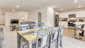 A modern kitchen with white cabinets, a microwave, and a refrigerator.