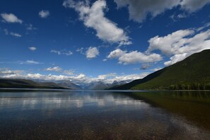 Ein ruhiger See mit Bergen im Hintergrund und einem klaren Himmel.