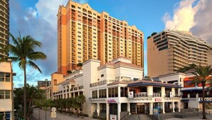 A hotel with multiple floors, a central entrance, and a street view with palm trees. - Marriotts BeachPlace Towers - 2 Bedroom (Fort Lauderdale)