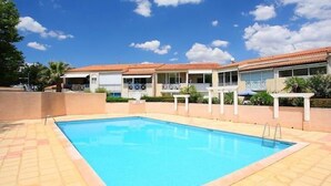 Une piscine à l’eau d’un bleu limpide, entourée d’une terrasse carrelée.