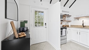 A modern kitchen with white cabinetry, a granite countertop, and a stainless steel oven. - Escape to Shenandoah River, Hot Tub after a Hike!  (Front Royal)