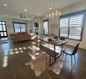 A spacious living area with a dining table, chairs, and a sofa.