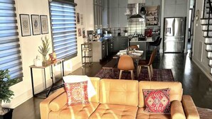 Ein modernes Wohnzimmer mit einer Ledersofa, einem Couchtisch und einem Essbereich im Hintergrund.