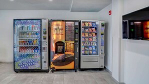 Una fila di distributori automatici con diverse bevande e snack.