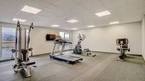 Una palestra con tapis roulant, cyclette e macchinari per l'allenamento con i pesi.