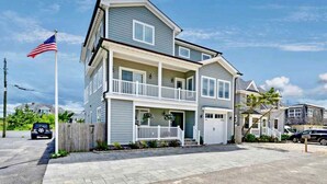 A two-story residential building with a balcony on the second floor, a garage, and a driveway. - Dream Beach House packed with Style, Comfort, and Convenience (Mantoloking)